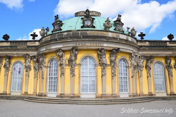 Frontalansicht des überkuppelten Mittelbaus von Schloss Sanssouci mit Rundbogenfenstern und Figurenhermen.